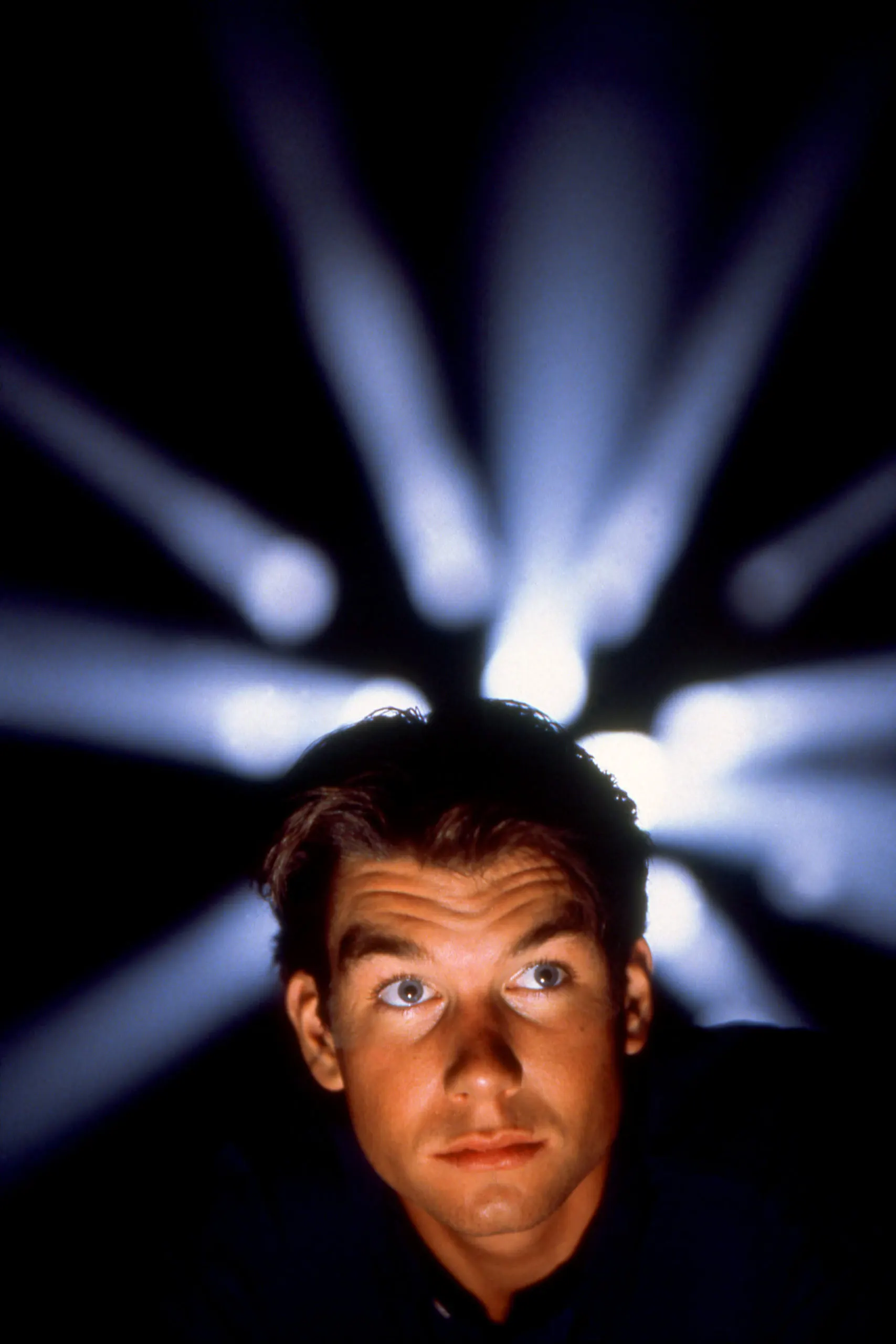 Sliders promo photo of Jerry O'Connell in front of blue prism lights