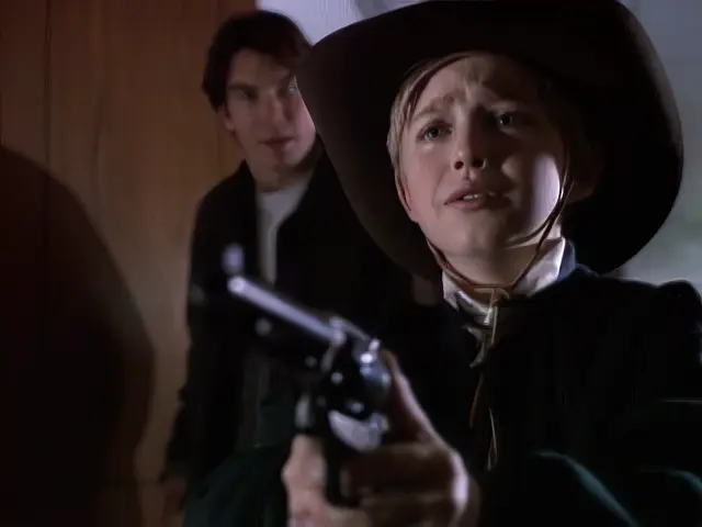 Quinn trying to stop Jamie, a young boy, from shooting Mr. Bullock in the episode The Good, The Bad and The Wealthy