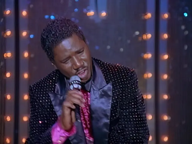 Rembrandt Brown, The Crying Man, sings on stage in the Sliders episode the King is Back